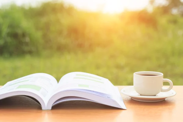 Taza de café y libro en la mesa por la mañana —  Fotos de Stock