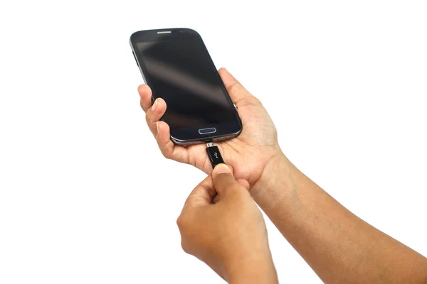 Mão segurando smartphone e conectar carregador isolado em ba branco — Fotografia de Stock