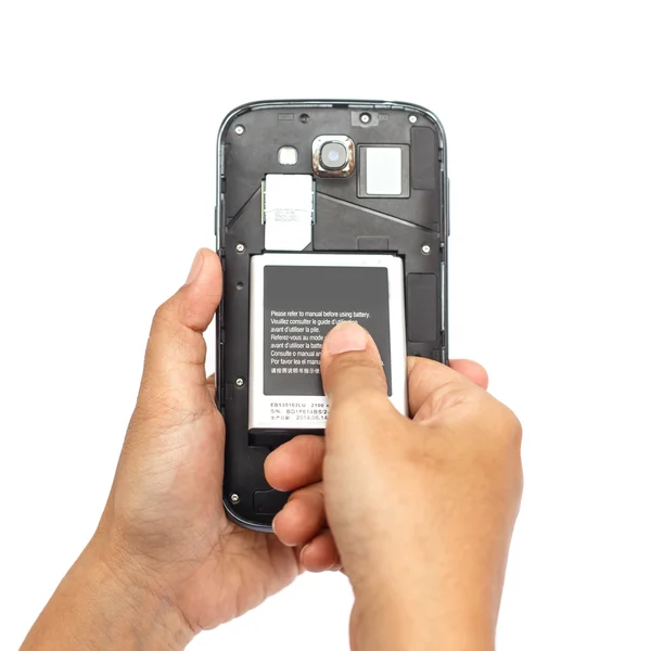 Mão segurando bateria de smartphone isolado no fundo branco — Fotografia de Stock