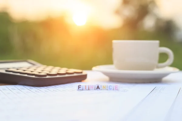 Finanzas escritas en abalorios y una taza de café en la mesa — Foto de Stock