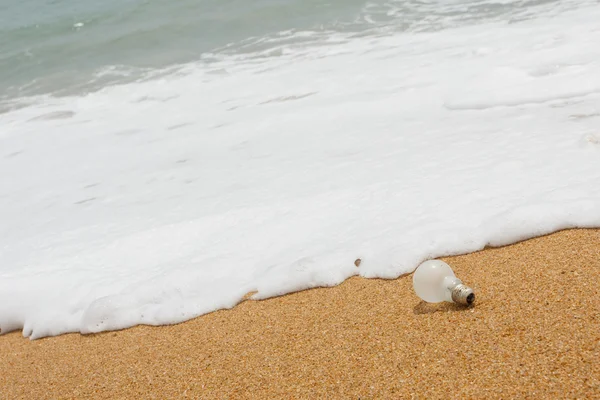 Old light bulb on the beach — Stock Photo, Image