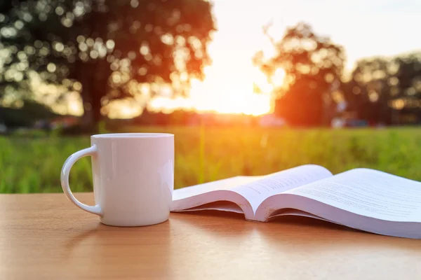 Taza de café y libro en la mesa por la mañana —  Fotos de Stock