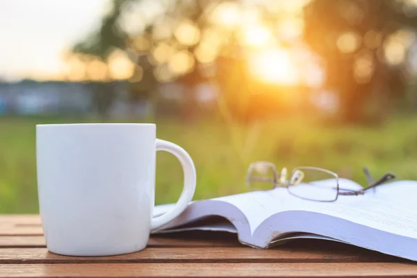 Taza de café y libro en la mesa por la mañana —  Fotos de Stock