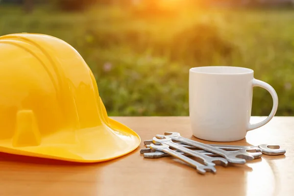 Cerrar taza de café y casco de seguridad en la mesa — Foto de Stock