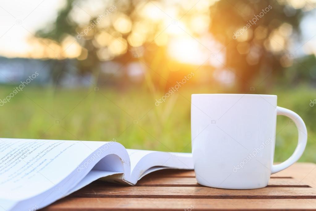 Coffee cup and book on the table in the morning