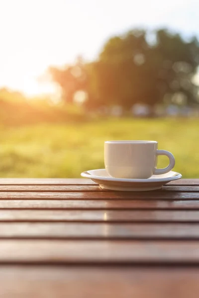 Koffiecup op tafel bij zonsondergang — Stockfoto
