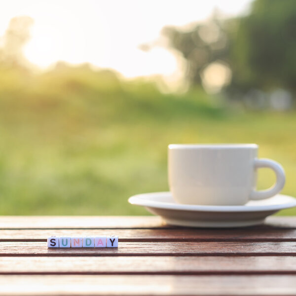Domingo escrito en abalorios y una taza de café en la mesa — Foto de Stock