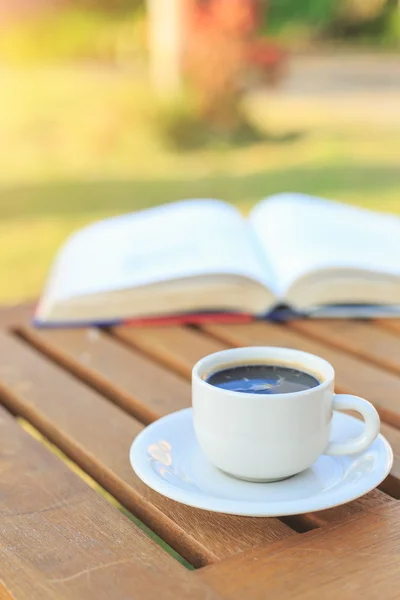 Xícara de café e livro na mesa pela manhã — Fotografia de Stock