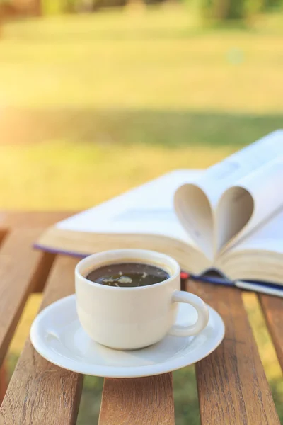 Xícara de café e livro na mesa pela manhã — Fotografia de Stock