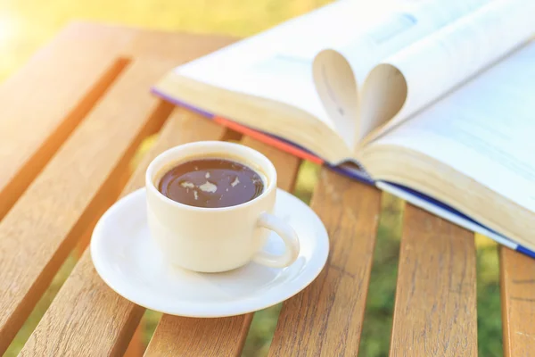 Koffiekopje en boek op de tafel in de ochtend — Stockfoto