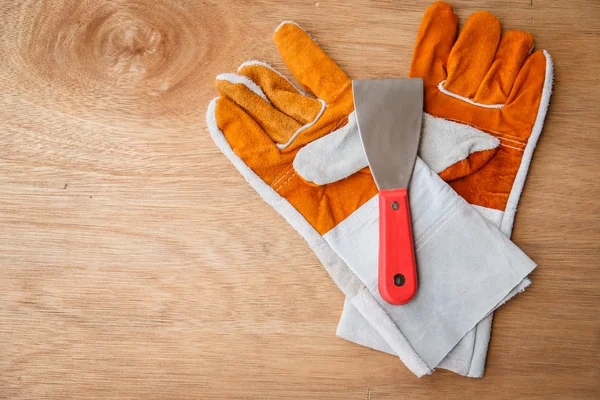 Kožené pracovní rukavice na hnědé dřevěné pozadí — Stock fotografie
