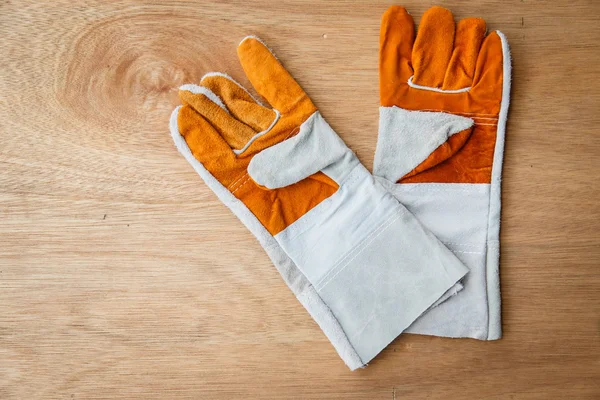 Leather work gloves on brown wood background — Stock Photo, Image