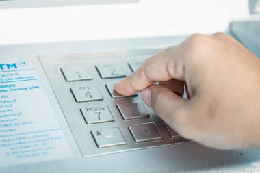 Close up of hand entering PIN pass code on ATM bank machine keyp clipart