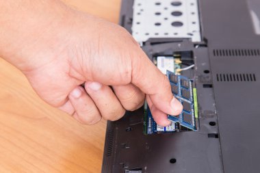 RAM laptop-in arka yüzüne tutan el