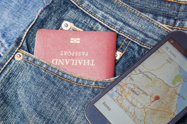 Pasaporte en bolsillo vaquero y mapa en smartphone —  Fotos de Stock