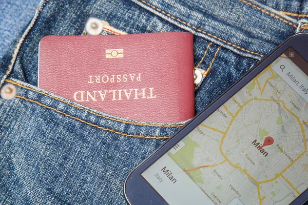 デニム ジーンズのポケットでスマート フォンで地図のパスポート — ストック写真