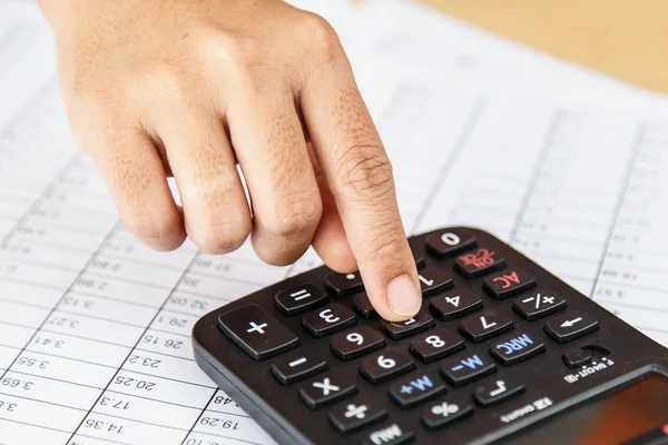 Close up hands pressing calculator buttons over documents — Stock Photo, Image