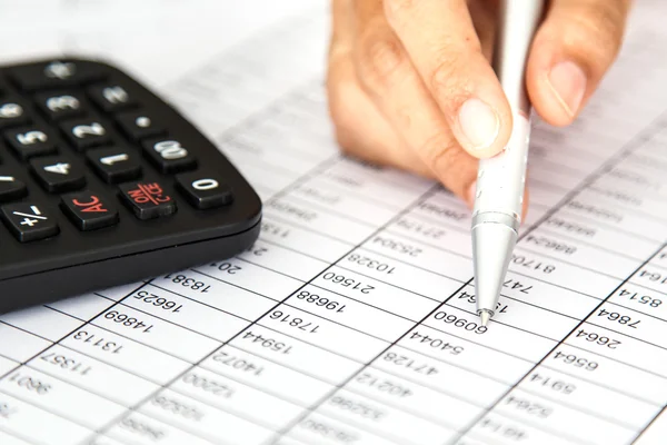 Close up woman hand holding pen on spreadsheet — Stock Photo, Image