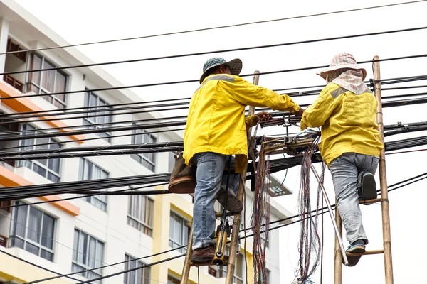 Trabajador en la escalera de bambú está reparando la línea telefónica —  Fotos de Stock