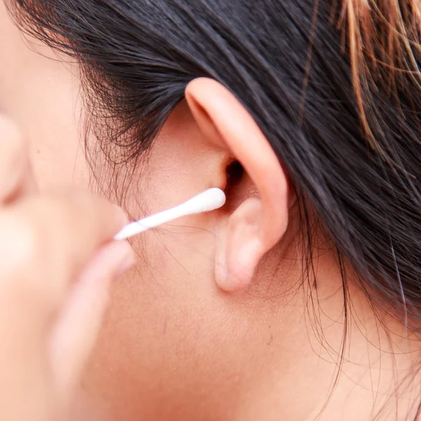 Mujer limpiando oreja usando bastón de algodón — Foto de Stock