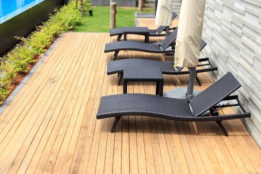 sun loungers stand on decking at pool clipart