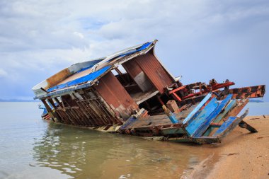 Eski ahşap tekne plajda durup 