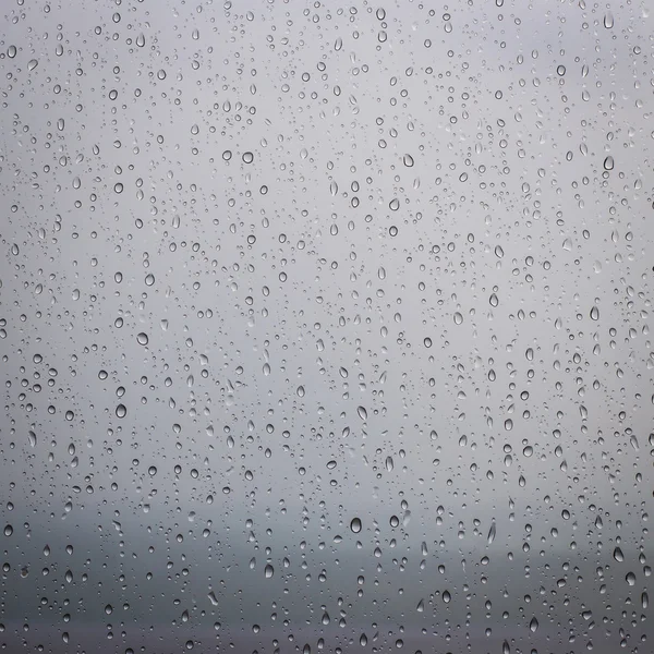 Gotas de chuva na superfície de vidro das janelas — Fotografia de Stock