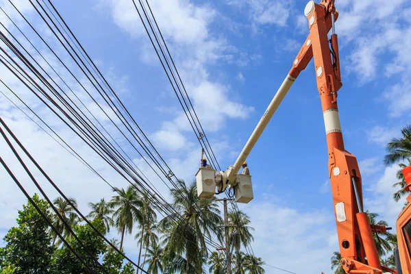 Electrician stays on the tower pole and repairs a wire of the po — Stock Photo, Image