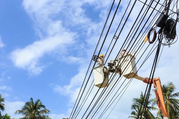 Electrician stays on the tower pole and repairs a wire of the po — Stock Photo, Image