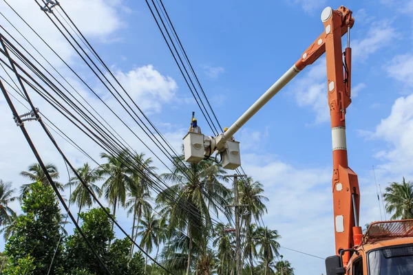 Electricista se queda en el poste de la torre y repara un cable del po — Foto de Stock