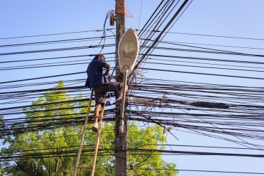 man on ladder fixing telephone line clipart