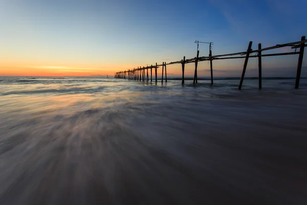 De lange houten brug bij zonsondergang sunset beach — Stockfoto