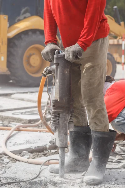 Arbejder ved hjælp af byggeri boring cement på jorden - Stock-foto