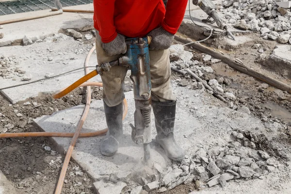 Trabajador que utiliza cemento de perforación de construcción en el suelo — Foto de Stock