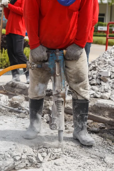 Pracownik przy użyciu budowlanych wiercenia cementu na ziemi — Zdjęcie stockowe