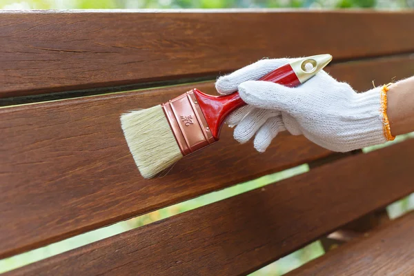 Hand som håller penseln och måla virke — Stockfoto