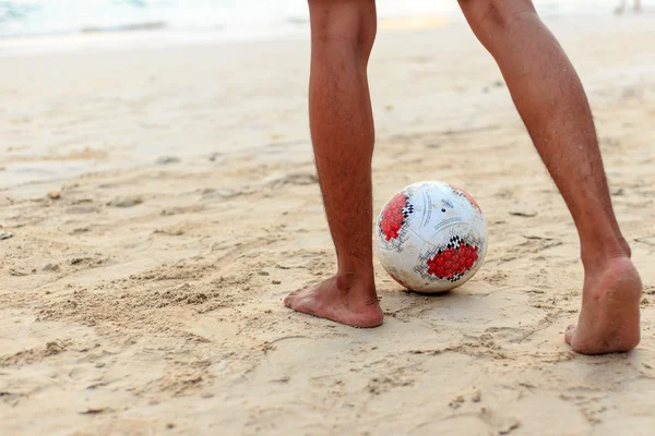 Primo piano del piede maschile che gioca a calcio sulla sabbia — Foto Stock