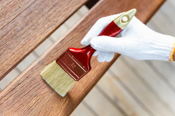 Hand holding brush and paint timber — Stock Photo, Image