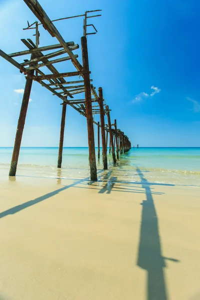 Puente largo de madera en la playa con cielo azul — Foto de Stock