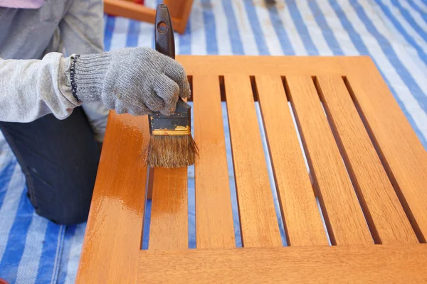Cepillo en la mano y pintura en los muebles de madera — Foto de Stock
