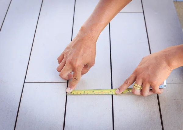 Hombre midiendo piso de madera con cinta métrica . — Foto de Stock