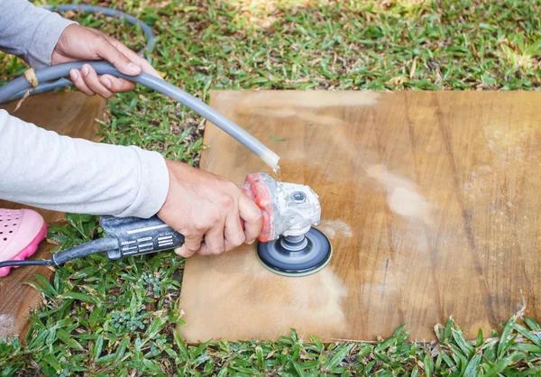 Man met haakse slijper te slijpen op zandsteen — Stockfoto