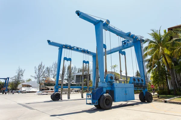 Crane lifting boats at harbor — Stock Photo, Image