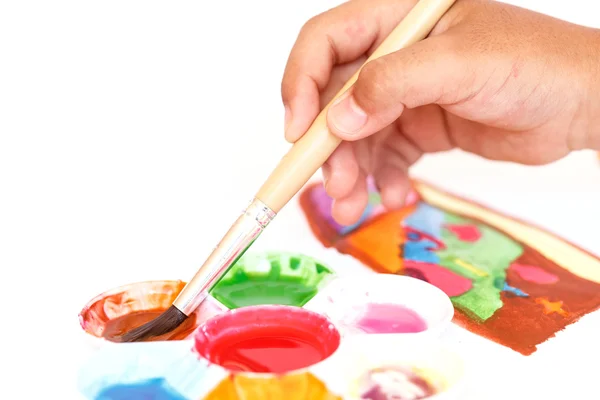 Close up hand holding brush with water paint tray