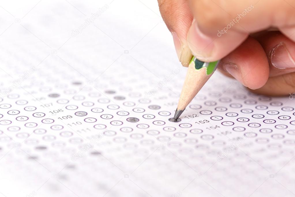 Hand with pencil on answer sheet