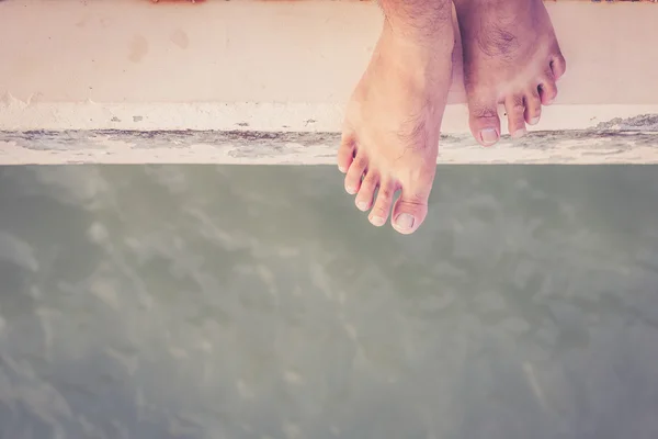 Pies desnudos en el borde del cemento — Foto de Stock