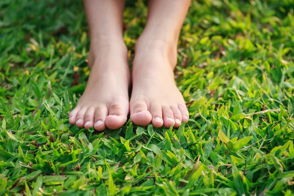 Stóp dzieci na zielonej trawie — Zdjęcie stockowe