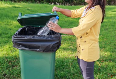 Eli boş plastik şişeyi çöpe atma