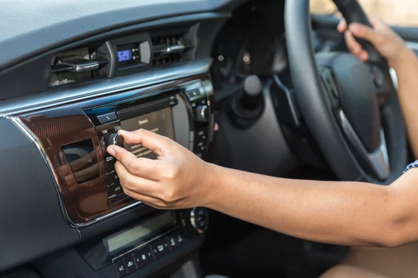 Mão ajustar o botão de áudio no carro — Fotografia de Stock