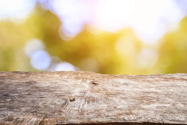 Tampo da mesa de madeira velha com bokeh da luz solar — Fotografia de Stock